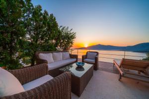 a patio with a couch and chairs and a sunset at Hotel Villa Mahal in Kalkan