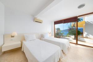 two beds in a room with a view of the ocean at Hotel Villa Mahal in Kalkan