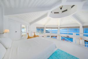 a white bedroom with a large bed and views of the ocean at Hotel Villa Mahal in Kalkan