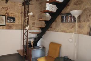 una camera con sedia e scala a chiocciola di A Staccia a Ragusa