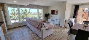 ein Wohnzimmer mit Sofa und Tisch in der Unterkunft Homes of Spain, Apartamentos Paraíso, Ed Palmerston, Atico O, Suite con Piscina Privada en solárium, vistas al mar, a 50 m de la playa, WIFI in Playas de Vera