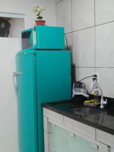 a blue refrigerator in a kitchen with a sink at Casa Rebello - Pousada in Itajaí