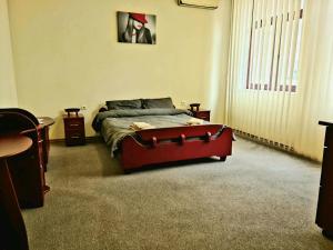 1 dormitorio con 1 cama con reposapiés rojo grande en DBS Hotel, en Bălţi