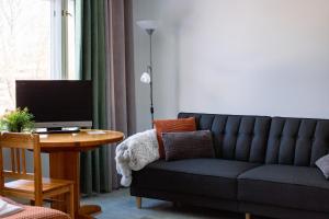 a living room with a couch and a table with a television at Hotel Kuusanka in Kuusamo