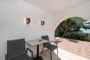 a dining room with a table and chairs on a patio at Elafonisi Resort by Kalomirakis Family in Elafonisi
