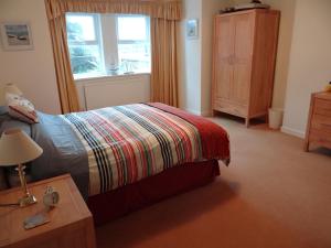 a bedroom with a bed and a dresser and a window at The Garden Flat in Hunstanton