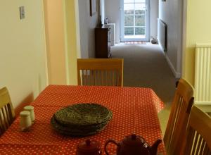 a room with a table with a red polka dot table cloth at The Garden Flat in Hunstanton
