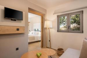 a living room with a tv on a wall at Elafonisi Resort by Kalomirakis Family in Elafonisi