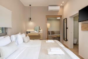 a large white bed in a room with a mirror at Elafonisi Resort by Kalomirakis Family in Elafonisi