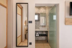 a bathroom with a glass door leading to a sink at Elafonisi Resort by Kalomirakis Family in Elafonisi