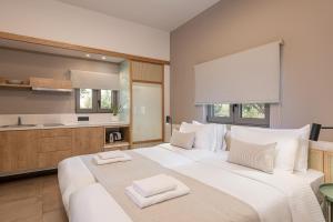 a bedroom with a large white bed with two towels on it at Elafonisi Resort by Kalomirakis Family in Elafonisi