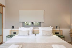 two beds in a bedroom with a window at Elafonisi Resort by Kalomirakis Family in Elafonisi