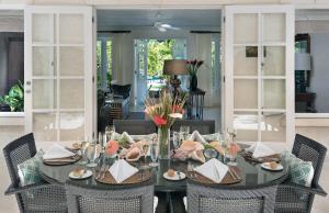 a dining room with a table with chairs and a tableablish at Coral Reef Club in Saint James
