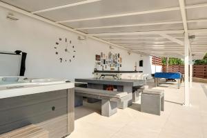 een eetkamer met tafels en een klok aan de muur bij Villa Prasino in Coral Bay