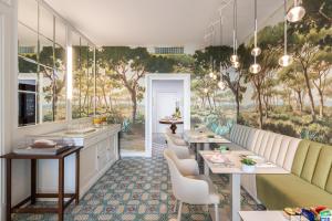 a restaurant with tables and chairs and a wall mural at Palazzo Marziale in Sorrento