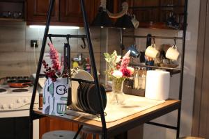a kitchen counter with a table with flowers on it at Apartman AS in Belgrade