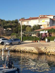 a boat in the water next to a parking lot at Apartments and rooms LJUBICA in Lun