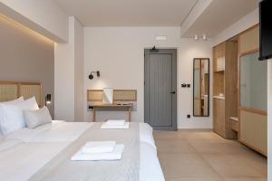 a bedroom with a large white bed and a desk at Elafonisi Resort by Kalomirakis Family in Elafonisi