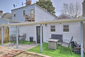 Cette maison blanche dispose d'une terrasse avec des chaises et une table. dans l'établissement Louisville Gem with Yard, Walk to Bars and Dining, à Louisville