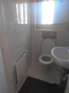 a white bathroom with a toilet and a sink at Pension Rückert in Kassel +15 photos