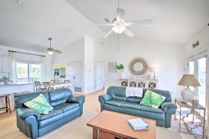a living room with two blue couches and a table at Pensacola Beach Home 1 Block to Beach Access in Pensacola Beach