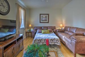 a living room with a brown leather couch and a clock at New Orleans Retreat about 3 Mi to Bourbon Street! in New Orleans