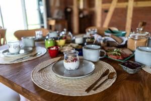 une table en bois avec des assiettes, des tasses et des ustensiles dans l'établissement Siedlisko pod Krukiem - Jurta, à Suwałki