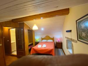 1 dormitorio con 1 cama con colcha de color naranja en 2 bedrooms house with lake view enclosed garden and wifi at Castelo do Neiva 2 km away from the beach B, en Castelo do Neiva