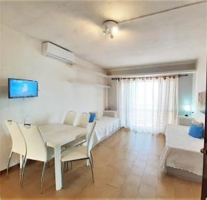 a dining room with a table and chairs and a couch at Baia de Bahas - Apartments & Resort in Santa Marinella