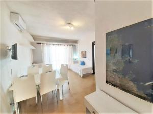 a dining room with a table and chairs and a bedroom at Baia de Bahas - Apartments & Resort in Santa Marinella