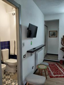 uma casa de banho com WC e uma televisão na parede em Retro' BeB em La Spezia