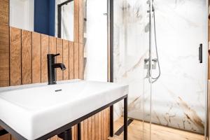 a bathroom with a white sink and a shower at AT Krakow Apartments in Krakow