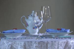 un tavolo con due bicchieri da vino e un vaso di CASA COM SPA DE HIDRO, AQUECEDOR E CROMOTERAPIA A 1,0 kM DO CENTRO a Chapada dos Guimarães