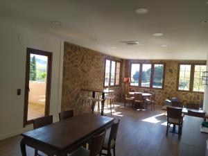 a dining room with tables and chairs and windows at Venta el Borrego in Banyeres de Mariola