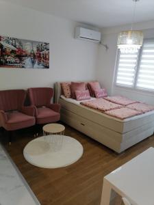 - un salon avec un lit et un canapé dans l'établissement Spring deluxe, à Novi Sad