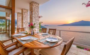 
a dining room table with chairs and a balcony overlooking the ocean at Hotel Villa Mahal in Kalkan
