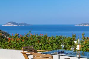 a table with wine glasses and a view of the ocean at Hotel Villa Mahal in Kalkan