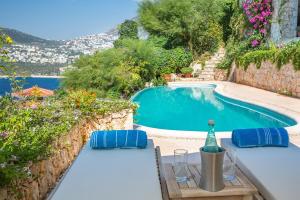 
a patio area with tables, chairs, and umbrellas at Hotel Villa Mahal in Kalkan
