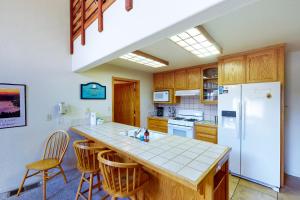 a kitchen with a white refrigerator and wooden cabinets at Streiff Lake House in Bass Lake