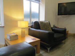 un soggiorno con divano, sedia e TV di Lynnfield Hall a Hunstanton