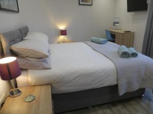 ein Schlafzimmer mit einem Bett mit zwei Handtüchern darauf in der Unterkunft Lynnfield Hall in Hunstanton