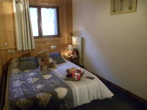 two teddy bears sitting on a bed in a bedroom at LA CORDEE in Valloire
