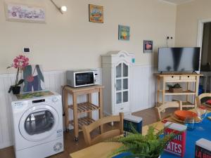 a living room with a washing machine and a tv at Bnbook Appartamento Sempione 4 Camere 4 Bagni in Rho