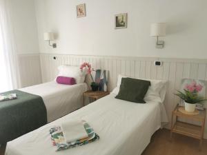 two beds in a room with white walls at Bnbook Appartamento Sempione 4 Camere 4 Bagni in Rho