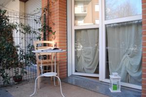 a chair sitting on a porch next to a window at Bnbook Appartamento Sempione 4 Camere 4 Bagni in Rho