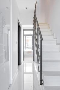 een trap in een huis met een zwarte leuning bij Sky Island House - Luxury Maisonette Kallithea in Kallithea