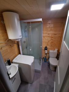 a bathroom with a shower and a toilet and a sink at Domek Letni in Gdynia