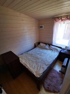 a bedroom with a bed in a room with a window at Domek Letni in Gdynia
