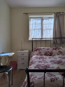 1 dormitorio con cama, ventana y escritorio en 1 Double room with shared bathroom en Bracknell