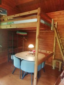 a room with a table and a bunk bed at La Cabane du Raideur in Cilaos